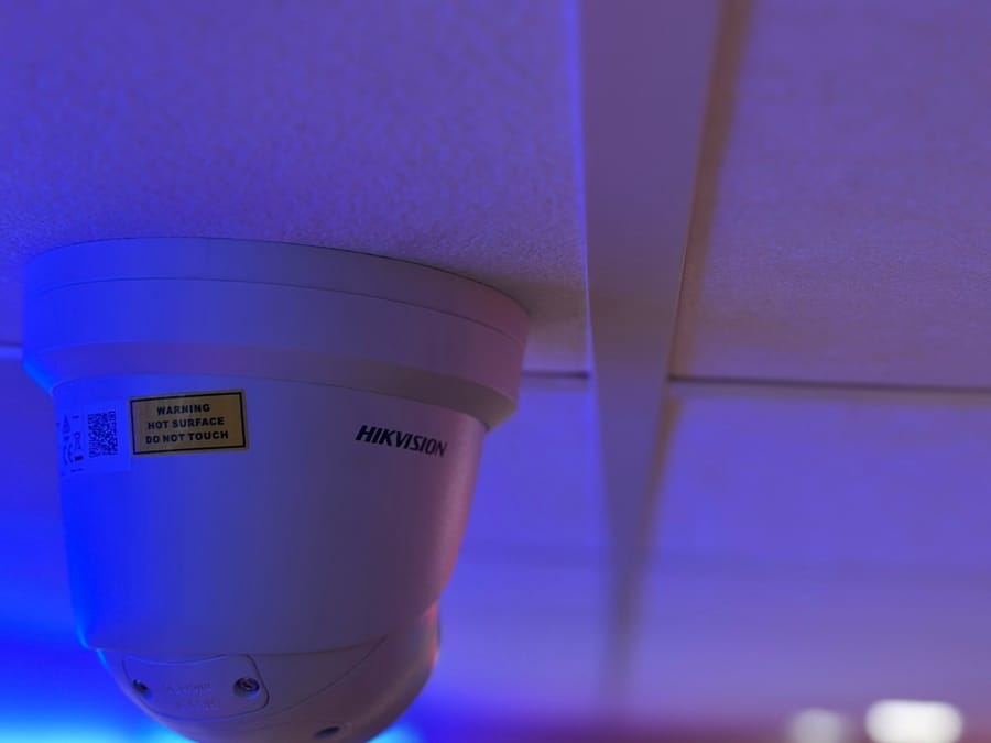 White Hikvision dome camera on an indoor ceiling