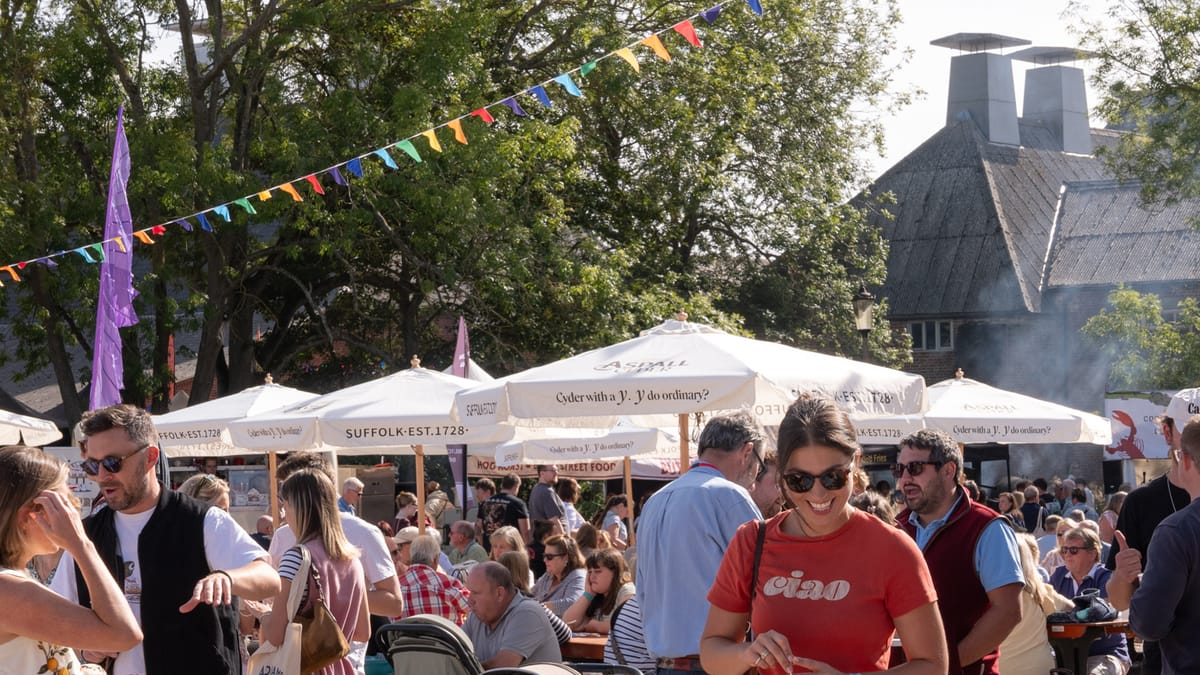 Festival-goers under bunting and parasols at the Aldeburgh Food & Drink Festival