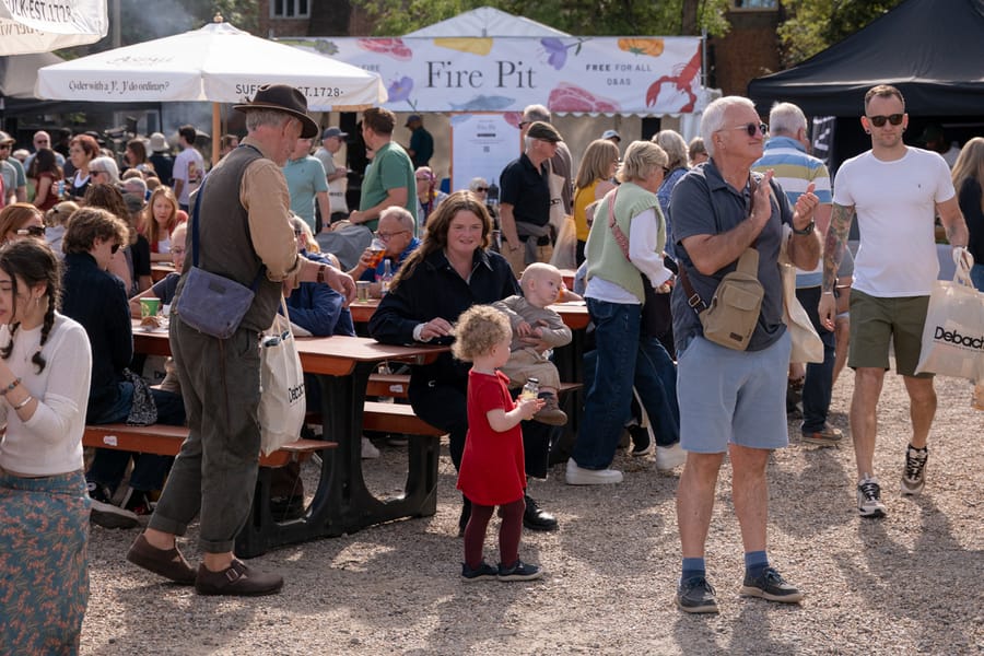 Visitors at the tables in front of the Fire Pit stage