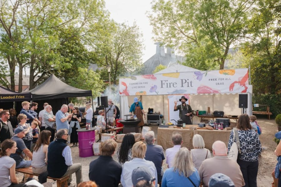 Crowd watching a live cooking demonstration on the Fire Pit stage