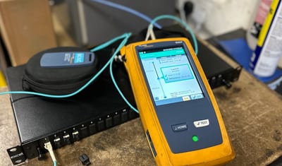Fluke Networks tester showing a passed fibre test on an Excel patch panel